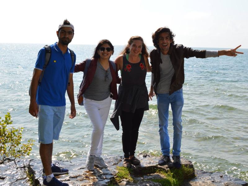 Four people standing on the shore